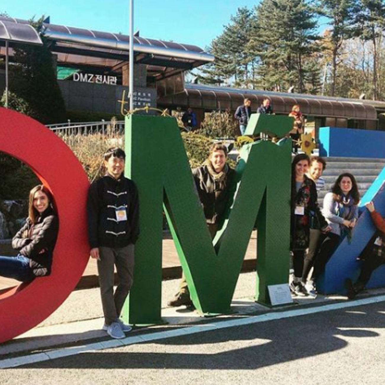 Group of students posing in a sign.